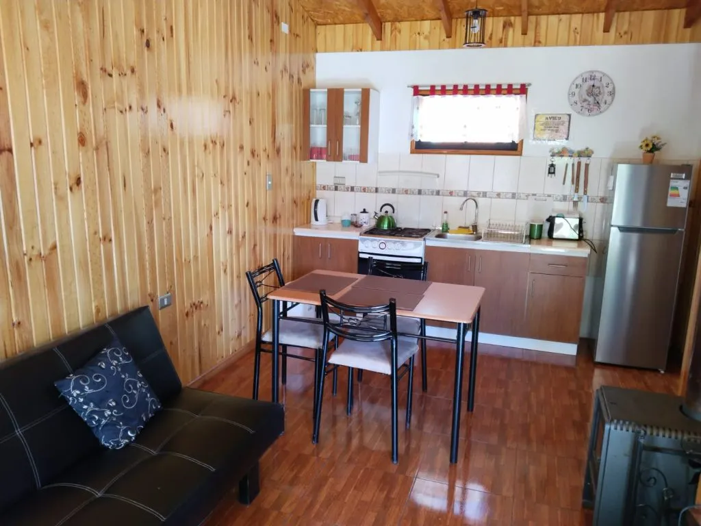 Exterior de Cabañas Fabi con terraza, sillas y jardín junto al Salto del Laja