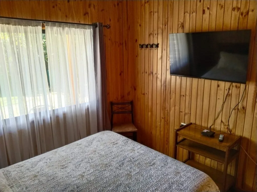 Cocina moderna con refrigerador, cocina a gas y comedor en cabaña Fabi